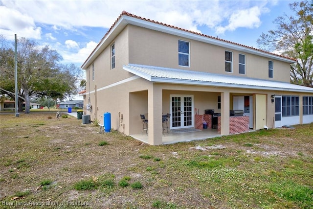 back of property with a patio, central AC unit, and french doors