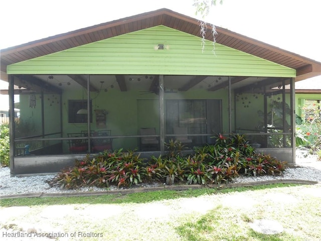back of property with a sunroom