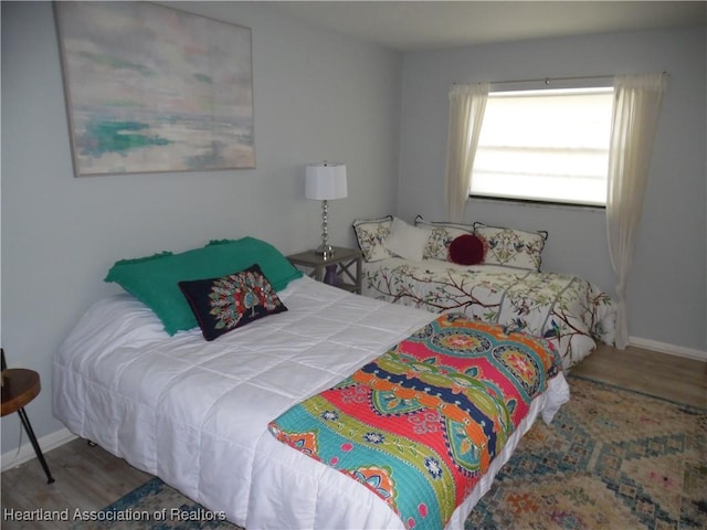 bedroom featuring baseboards and wood finished floors