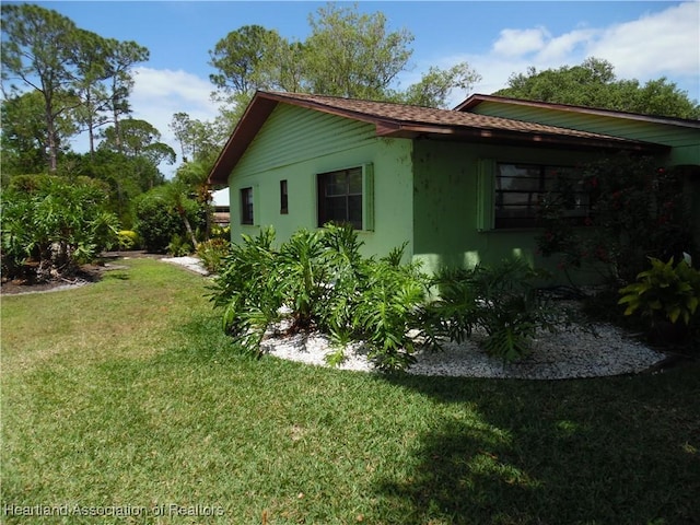 view of side of property with a lawn and stucco siding