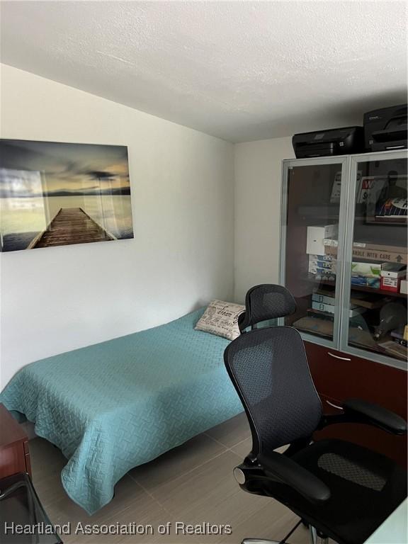 bedroom featuring light tile patterned flooring and a textured ceiling