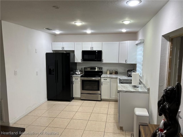 kitchen with sink, light tile patterned floors, white cabinets, and black appliances