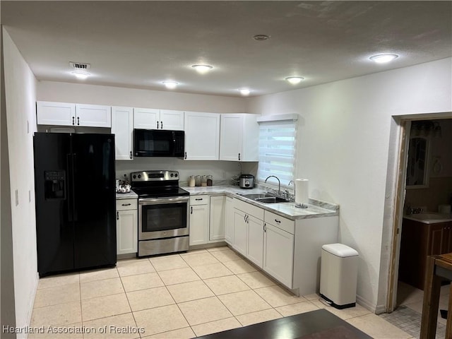 kitchen with sink, light tile patterned floors, white cabinets, and black appliances