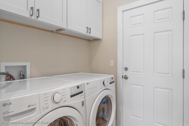 washroom featuring washer and clothes dryer and cabinets