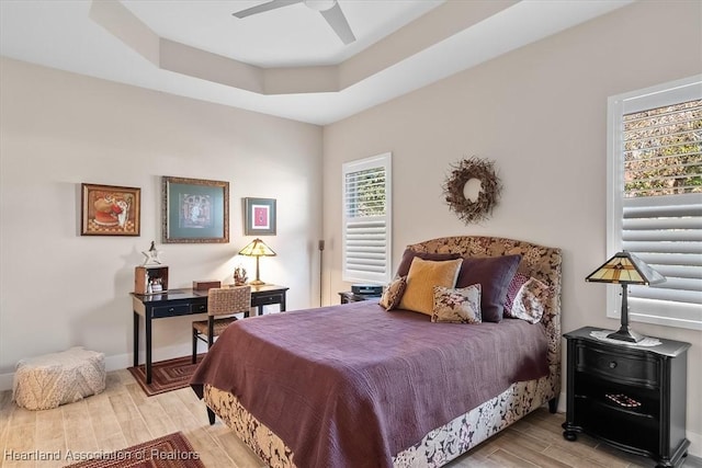 bedroom with ceiling fan and a tray ceiling