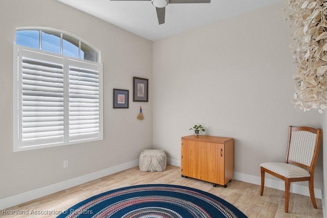 living area with hardwood / wood-style floors and ceiling fan