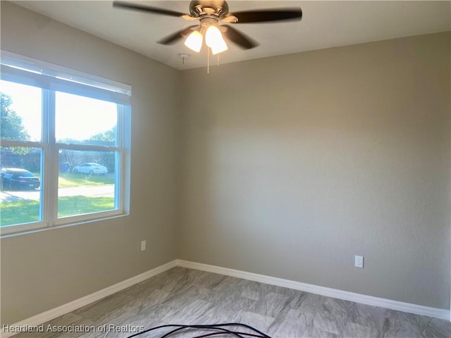 spare room featuring plenty of natural light and ceiling fan