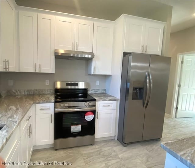 kitchen featuring white cabinets, appliances with stainless steel finishes, and light stone countertops