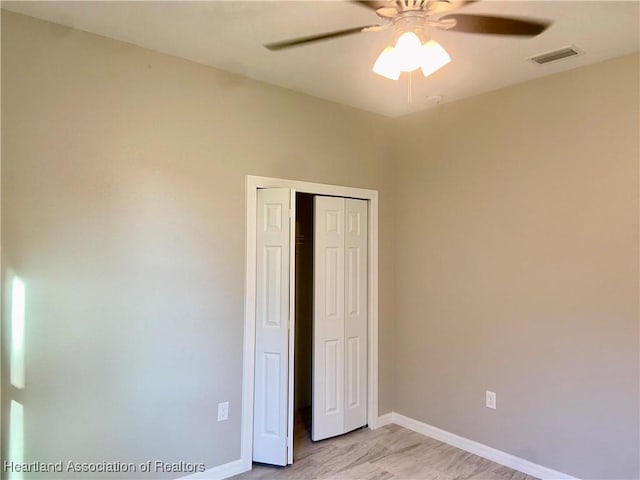 unfurnished bedroom featuring ceiling fan and a closet