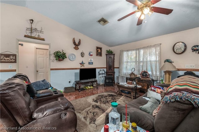 living room with lofted ceiling, a wood stove, visible vents, and a ceiling fan