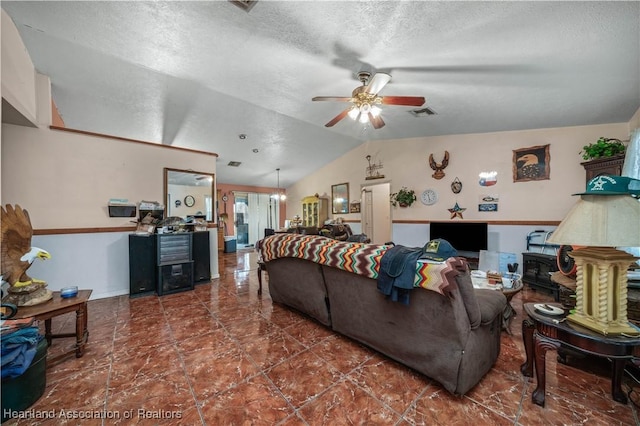 living area with a ceiling fan, vaulted ceiling, and a textured ceiling