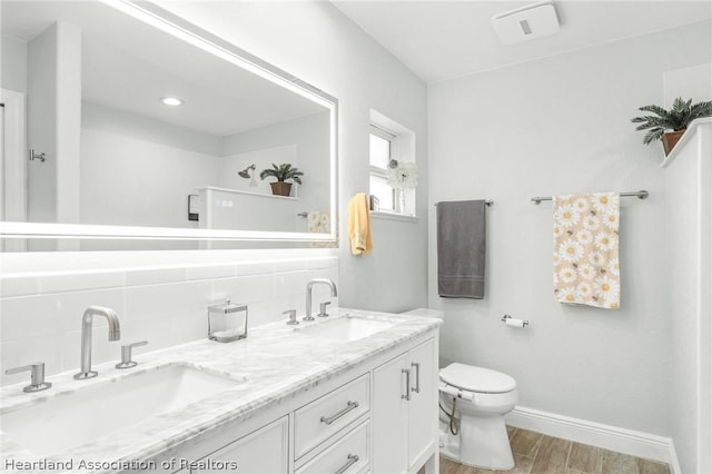 bathroom featuring vanity, tasteful backsplash, and toilet