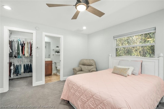 bedroom featuring ensuite bath, ceiling fan, a closet, and light colored carpet