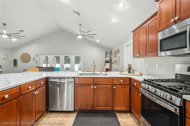 kitchen with kitchen peninsula, sink, vaulted ceiling, and appliances with stainless steel finishes