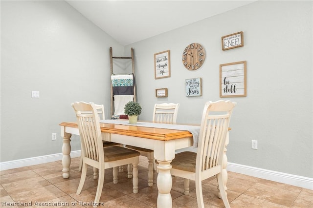 dining area with vaulted ceiling and light tile patterned flooring