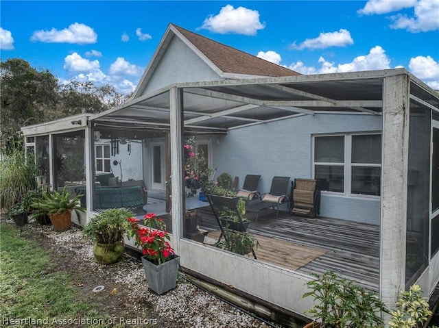 exterior space with a wooden deck and a sunroom