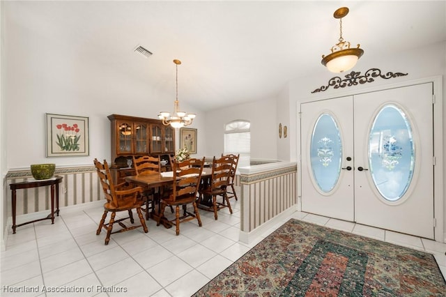 tiled entryway featuring an inviting chandelier and french doors