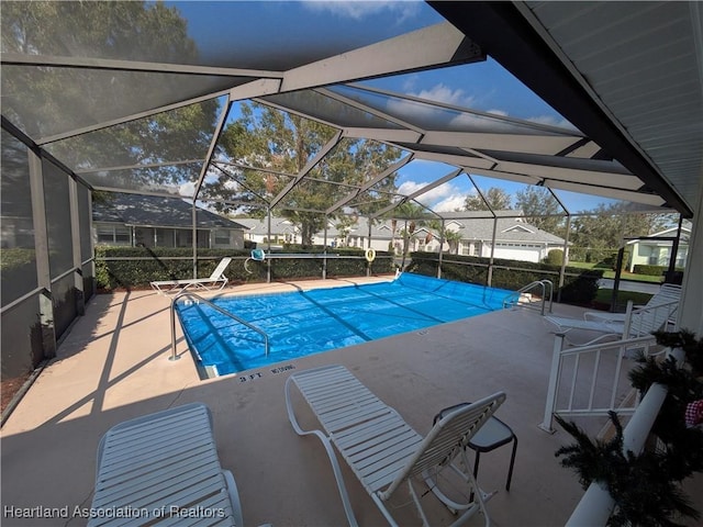 view of pool with a patio area and a lanai