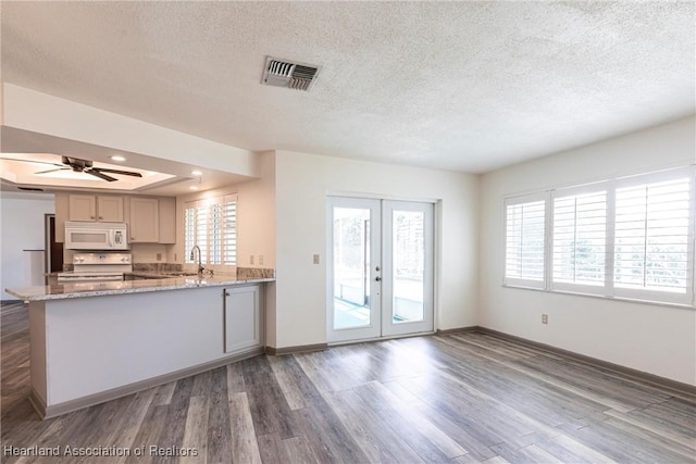 1811 Jackson Dr, Sebring, FL 33870 - kitchen featuring visible vents, plenty of natural light, white appliances, wood finished floors, and a sink