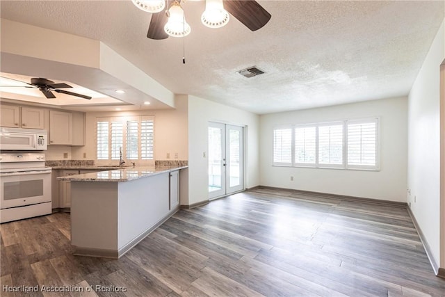 1811 Jackson Dr, Sebring, FL 33870 - kitchen featuring wood finished floors, a peninsula, white appliances, visible vents, and ceiling fan