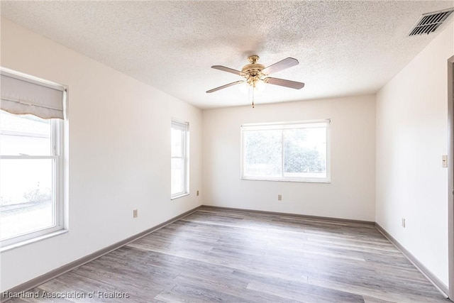 1811 Jackson Dr, Sebring, FL 33870 - unfurnished room with a textured ceiling, ceiling fan, visible vents, and wood finished floors