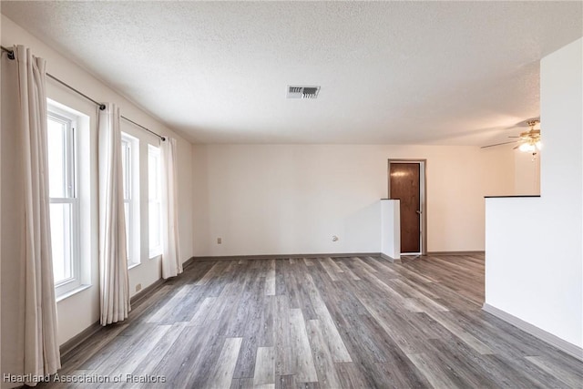 1811 Jackson Dr, Sebring, FL 33870 - spare room with a ceiling fan, wood finished floors, a textured ceiling, baseboards, and visible vents