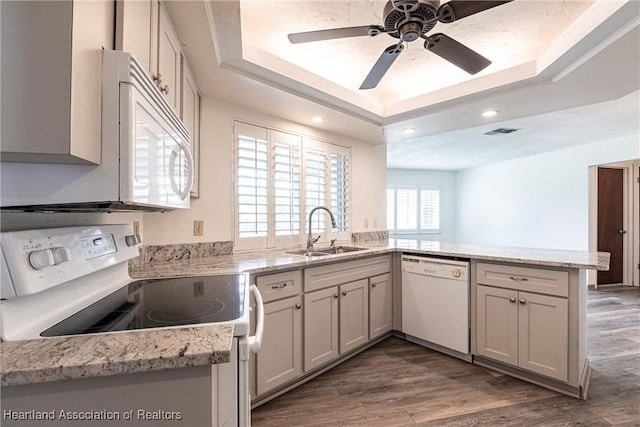 1811 Jackson Dr, Sebring, FL 33870 - kitchen with a tray ceiling, white appliances, a sink, ceiling fan, and a peninsula