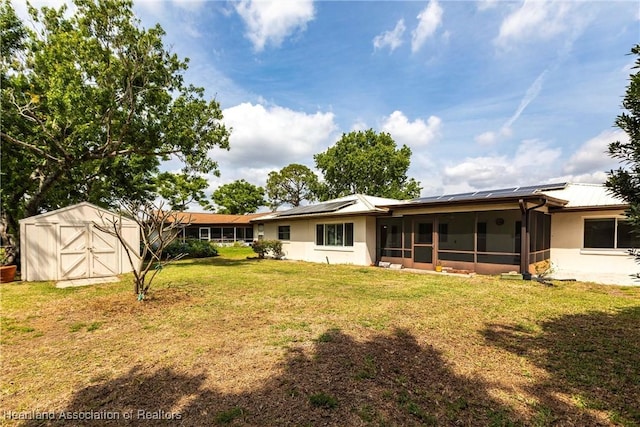 1811 Jackson Dr, Sebring, FL 33870 - rear view of property featuring a sunroom, roof mounted solar panels, a lawn, an outdoor structure, and a shed