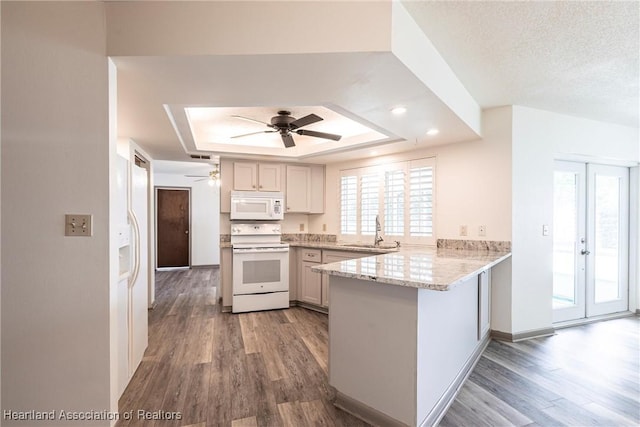 1811 Jackson Dr, Sebring, FL 33870 - kitchen with a ceiling fan, a raised ceiling, wood finished floors, a peninsula, and white appliances