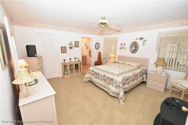 carpeted bedroom featuring ensuite bath and ceiling fan