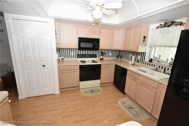 kitchen with light brown cabinetry, light hardwood / wood-style floors, black appliances, ceiling fan, and sink