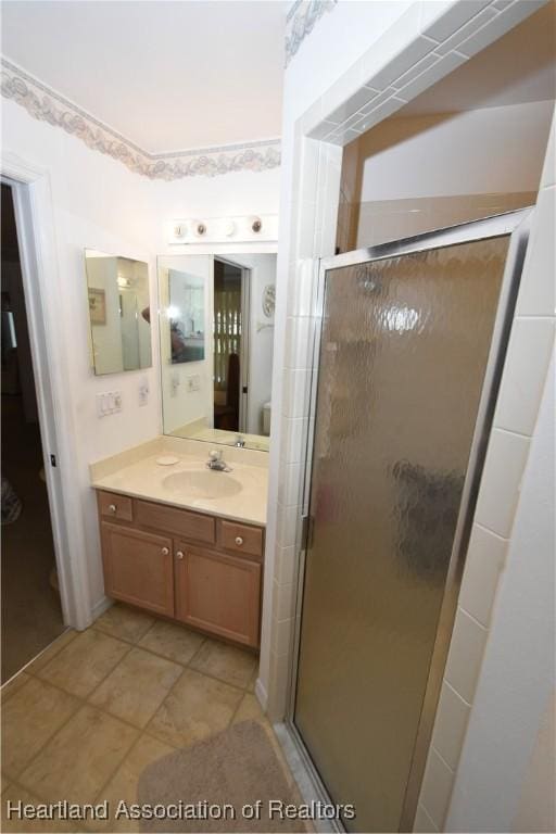 bathroom featuring vanity, tile patterned flooring, and a shower with shower door