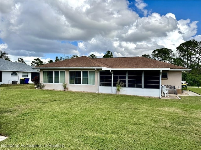 rear view of property with a yard and a sunroom