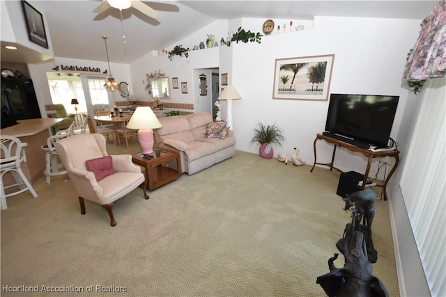 living room with ceiling fan, vaulted ceiling, and light carpet