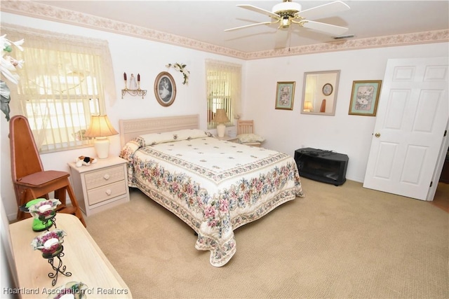 bedroom with ceiling fan and light carpet