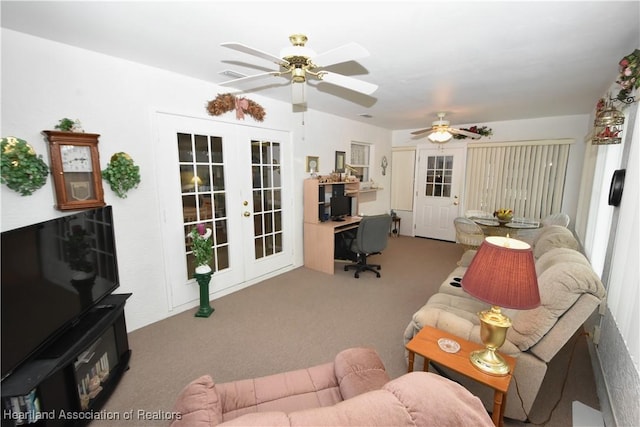 carpeted living room with ceiling fan and french doors