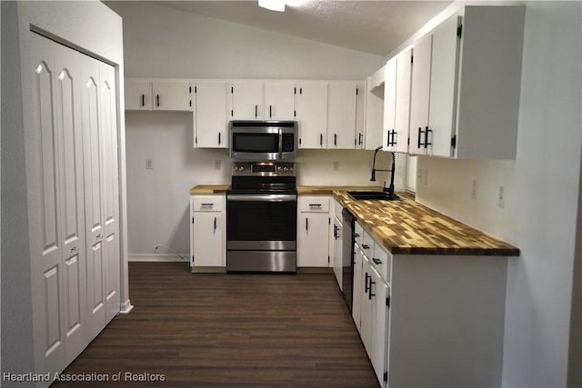 1922 N Torrington Rd, Avon Park, FL 33825 - kitchen with appliances with stainless steel finishes, dark wood finished floors, lofted ceiling, white cabinets, and butcher block counters