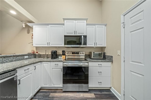 kitchen featuring light stone countertops, white cabinets, and stainless steel appliances