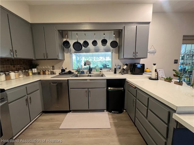 kitchen with gray cabinetry, sink, and stainless steel dishwasher