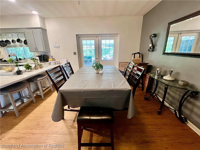 dining area with light wood-style floors, french doors, and plenty of natural light