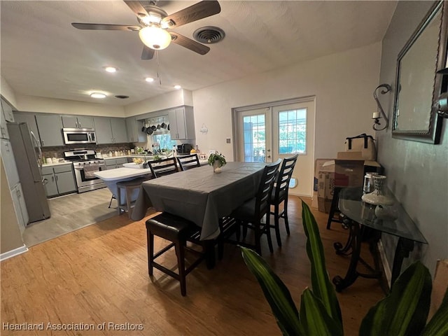 dining area with ceiling fan, french doors, and light hardwood / wood-style floors