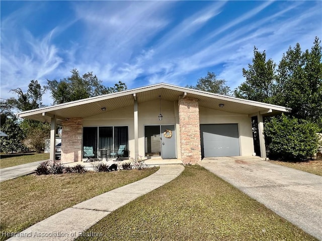 mid-century home with a garage, concrete driveway, a porch, a front lawn, and stucco siding