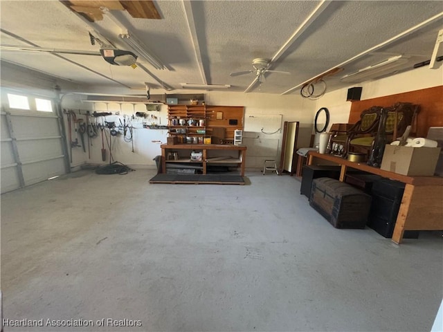 garage with a workshop area, a garage door opener, and ceiling fan