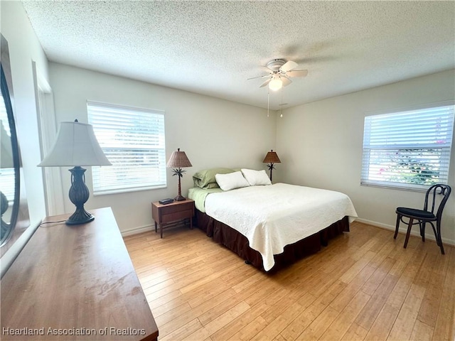 bedroom featuring multiple windows, light wood-type flooring, and ceiling fan