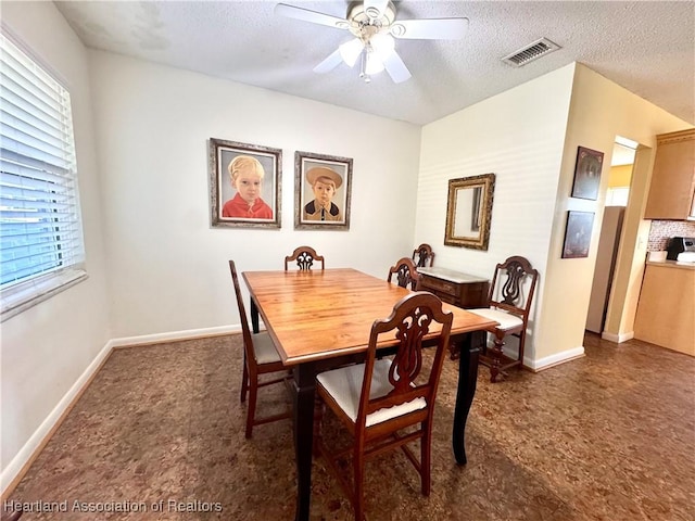 dining area with ceiling fan and a textured ceiling