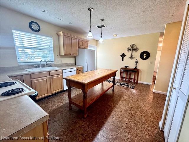 kitchen with white appliances, sink, a textured ceiling, light brown cabinetry, and decorative light fixtures