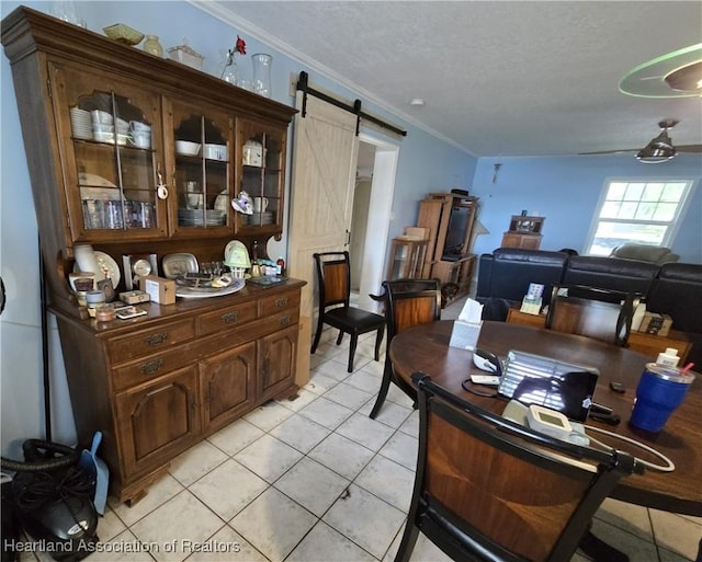 2068 Oak Blvd, Sebring, FL 33875 - dining room with a barn door, light tile patterned floors, a textured ceiling, and crown molding
