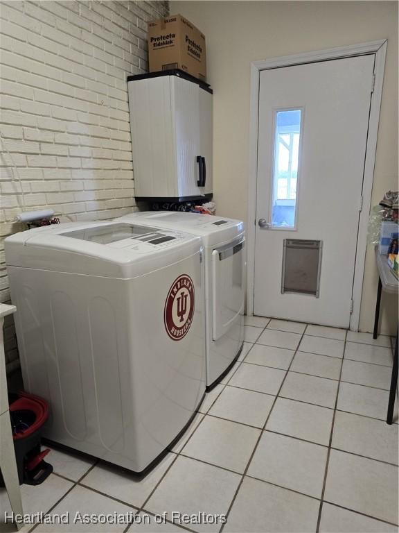 2068 Oak Blvd, Sebring, FL 33875 - washroom featuring brick wall, washing machine and dryer, and light tile patterned floors