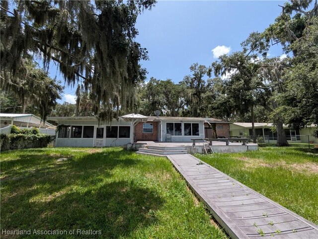 2068 Oak Blvd, Sebring, FL 33875 - back of property featuring a sunroom, a lawn, and brick siding