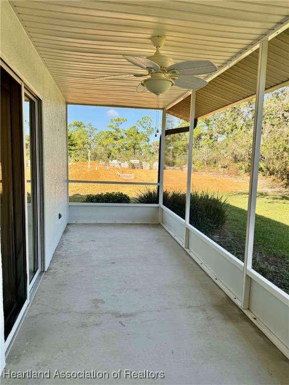 unfurnished sunroom with ceiling fan